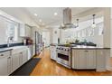 Modern open kitchen with stainless appliances, farmhouse sink, and view to the living room at 1346 Steele St, Denver, CO 80206