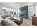 Cozy living room featuring a sleek electric fireplace, plush sofa, and bright natural light at 11524 Dewey St, Parker, CO 80138