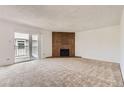 Spacious living room with a cozy brick fireplace and sliding doors to balcony at 3436 S Locust St # D, Denver, CO 80222