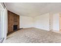 Bright, carpeted living room with a brick fireplace at 3436 S Locust St # D, Denver, CO 80222