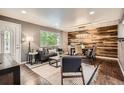Open-concept living room with wood accent wall, hardwood floors, and modern furniture at 6046 Vrain St, Arvada, CO 80003
