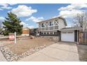 An appealing two-story home with a unique brick and grey facade, attached garage and low-maintenance front yard at 7668 Ellen Ln, Denver, CO 80221