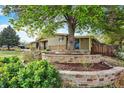 Landscaped flower beds and mature trees, enhance the home's curb appeal at 7895 W 67Th Ave, Arvada, CO 80004