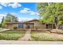 Inviting home exterior with landscaped front yard and brick pathway leading to the entrance at 7895 W 67Th Ave, Arvada, CO 80004