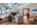 Sunlit living room with hardwood floors, fireplace, and open layout to dining area at 2541 Bellaire St, Denver, CO 80207