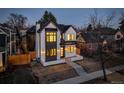 Charming two-story home showcasing its stylish white brick, contrasting black trim, and well-manicured surroundings at 352 S High St, Denver, CO 80209