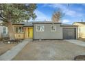 Cozy home with gray siding, light wood accents, attached garage and bright yellow door at 1765 Kingston St, Aurora, CO 80010