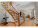 Inviting foyer with a curved staircase, hardwood floors, and a glimpse into a beautifully furnished living room at 20922 E Crestline Cir, Centennial, CO 80015