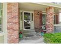 Cozy front porch featuring brick columns, a welcome mat, and decorative potted plants, creating an inviting entrance at 20922 E Crestline Cir, Centennial, CO 80015