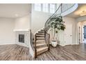 Elegant curved staircase with decorative iron railings and a tiled fireplace at 1715 Pioneer Cir, Lafayette, CO 80026