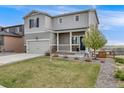 Inviting two-story home featuring a well-manicured lawn, charming front porch and attached two-car garage at 4811 River Highlands Loop, Elizabeth, CO 80107
