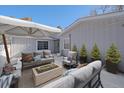 Cozy patio with cushioned seating, an umbrella, and a modern fire pit for outdoor enjoyment at 2761 S Xanadu Way, Aurora, CO 80014