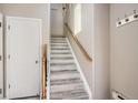 Bright entryway with painted staircase, wooden handrail, coat hooks, and a nearby closet at 3370 Cascina Cir # D, Highlands Ranch, CO 80126