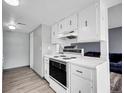 A bright kitchen features classic white cabinets and appliances, and light flooring at 3355 S Flower St # 131, Lakewood, CO 80227