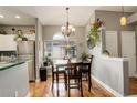 Bright dining area featuring wood floors, chandelier, and large window with plants at 8422 S Upham Way # H75, Littleton, CO 80128