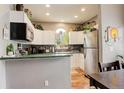 Well-lit kitchen with white cabinets, green countertops, and stainless steel appliances at 8422 S Upham Way # H75, Littleton, CO 80128