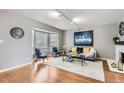 Bright living room featuring hardwood floors, bay window, fireplace, and modern decor at 7114 E Briarwood Dr, Centennial, CO 80112
