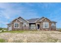 Gorgeous single story home with a combination of stone and gray siding, and a well-maintained front yard at 9727 Red Primrose St, Franktown, CO 80116