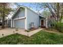 Charming blue home with a well-manicured lawn and walkway leading to the front door at 17613 E Ohio Cir, Aurora, CO 80017