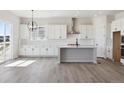 Modern kitchen with white cabinets, an island, and stainless steel appliances at 4704 Twelve Oaks Way, Castle Rock, CO 80104