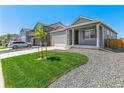 Single-story home with a tidy front lawn, rock landscaping, and an attached two-car garage at 13487 Valentia St, Thornton, CO 80602