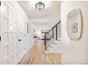 Bright hallway featuring hardwood floors, black metal railing, and modern light fixtures at 6889 Frying Pan Rd, Boulder, CO 80301