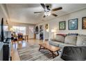 Bright living room with hardwood floors, a ceiling fan and a view of the front entrance and dining area at 6095 W 47Th Ave, Wheat Ridge, CO 80033