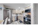 Bright kitchen with stainless steel appliances, tile backsplash, and light wood cabinetry at 8826 E Florida Ave # G12, Denver, CO 80247