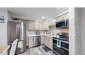 Bright kitchen with stainless steel appliances, light cabinetry, and a modern tile backsplash at 8826 E Florida Ave # G12, Denver, CO 80247