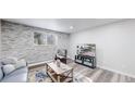 Cozy living room featuring a stone accent wall, large window, and modern decor at 8826 E Florida Ave # G12, Denver, CO 80247