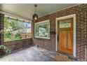 Inviting front porch featuring brick accents, a hanging lantern, and wood door at 3019 Meade St, Denver, CO 80211