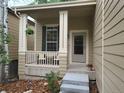 Inviting front porch with a cozy seating area, perfect for enjoying quiet moments and greenery at 10386 Ravenswood Way, Highlands Ranch, CO 80130