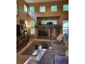 Bright living room features a fireplace, high ceilings, and large windows offering ample natural light at 10386 Ravenswood Way, Highlands Ranch, CO 80130