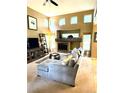 Spacious living room featuring a cozy fireplace, complemented by soaring ceilings and an abundance of natural light at 10386 Ravenswood Way, Highlands Ranch, CO 80130