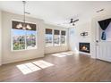 Bright living room with a fireplace, wood floors, and an abundance of natural light from large windows at 5755 S Buchanan Ct # E, Aurora, CO 80016