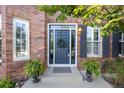Inviting front entry featuring a classic door with wreath, surrounded by lush ferns and brick facade at 17925 E Maplewood Dr, Aurora, CO 80016