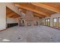 Expansive living room with a unique brick fireplace, bar, vaulted wood ceilings, and views of the wooded hillside at 5197 Bear Mountain Dr, Evergreen, CO 80439