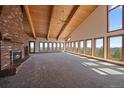 Bright living room with large windows offering scenic views, vaulted ceilings, and a striking brick fireplace at 5197 Bear Mountain Dr, Evergreen, CO 80439