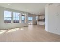 Bright and spacious living room featuring hardwood floors and natural light from large windows at 710 N Deer Park, Watkins, CO 80137