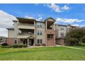 A sunny exterior showing the building's balconies and well-maintained grounds at 12816 Ironstone Way # 203, Parker, CO 80134