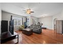 The inviting living room has gleaming hardwood floors and a ceiling fan at 12816 Ironstone Way # 203, Parker, CO 80134