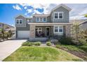 Inviting two-story home with a stone facade, manicured lawn, and a welcoming front porch at 9380 Bear River St, Littleton, CO 80125