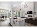 Open-concept kitchen featuring a large island, modern lighting, and seamless flow to the living area at 9380 Bear River St, Littleton, CO 80125