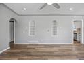 Spacious living room with stylish wood flooring, recessed lighting, and built-in shelving at 2582 S Uno Way, Denver, CO 80219