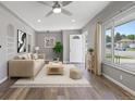 Bright living room features a ceiling fan, large window, and neutral decor and accents at 2582 S Uno Way, Denver, CO 80219