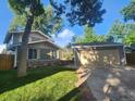 Charming home featuring a lush lawn, mature trees, and a detached two-car garage at 6207 W 92Nd Pl, Westminster, CO 80031