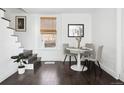 Dining area with modern table, chairs, and hardwood floors with natural light from large window at 1535 Spruce St, Denver, CO 80220