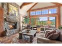 Cozy living room with stone fireplace, mountain views, and comfortable seating at 2929 Highlands View Rd, Evergreen, CO 80439