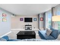 Bright living room featuring large windows and comfortable blue sofas at 5955 E 10Th Ave # 507, Denver, CO 80220