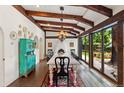 Bright dining room with exposed beams, large windows overlooking the backyard, and a vintage hutch at 50 Albion St, Denver, CO 80220